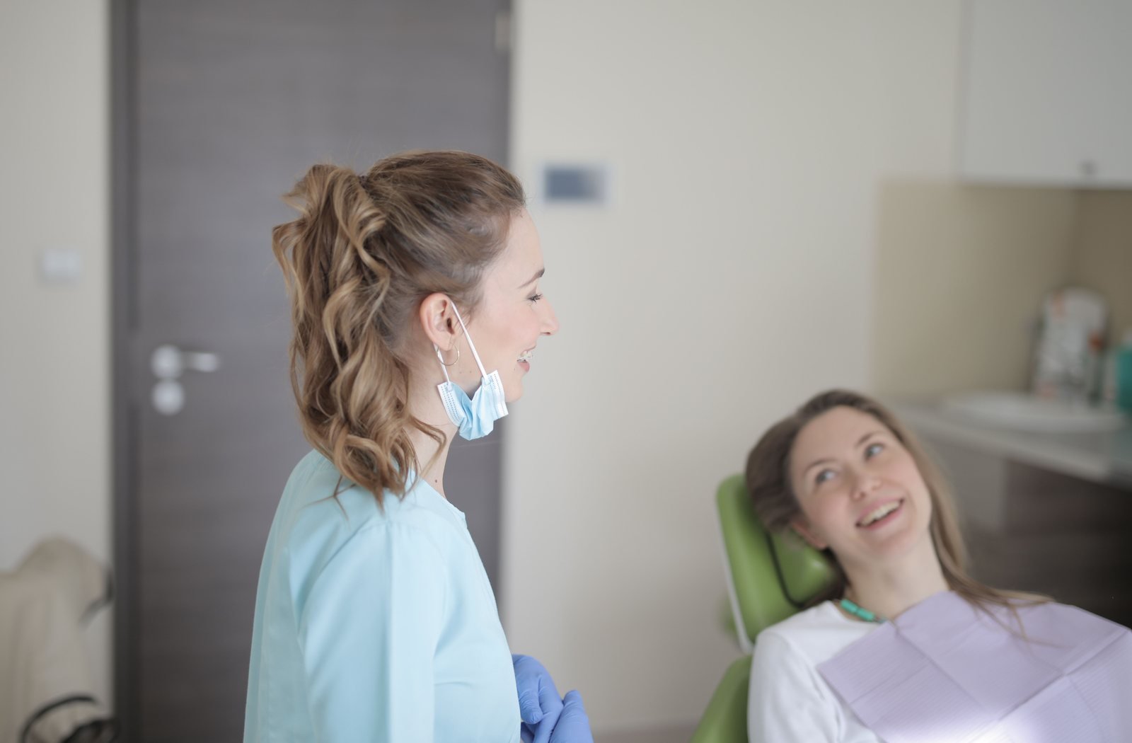 Dentista conversando con una paciente en un consultorio moderno